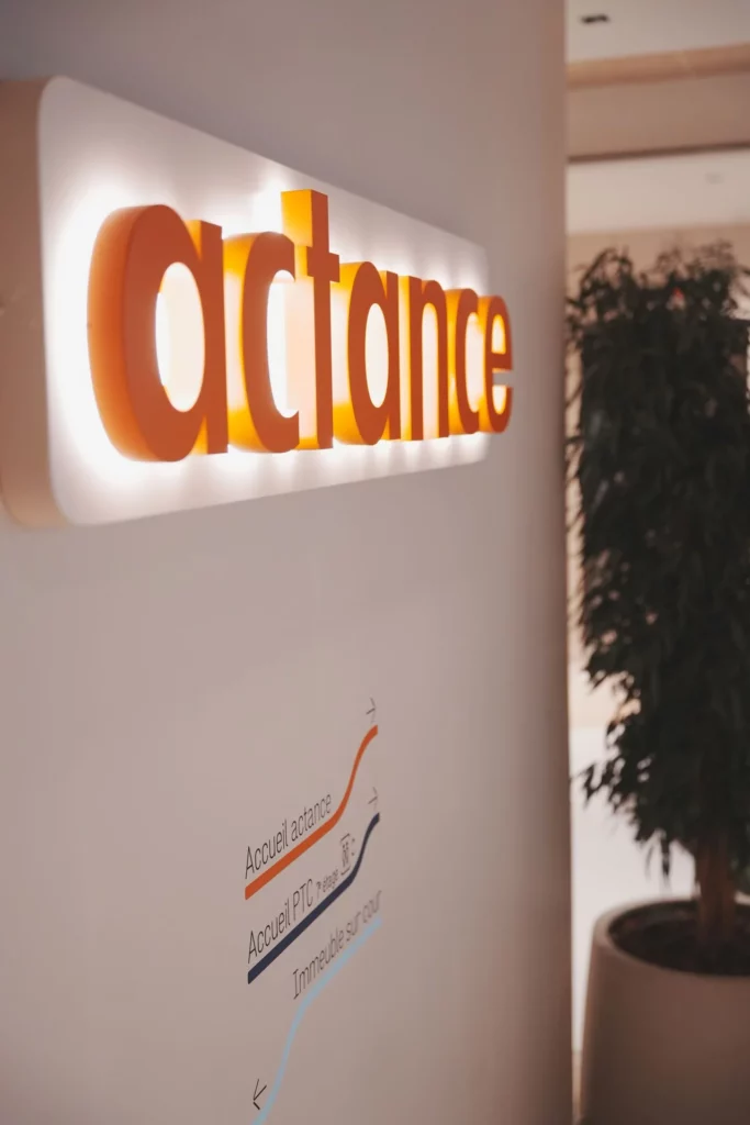 Identité Actance sur un mur éclairé dans les bureaux