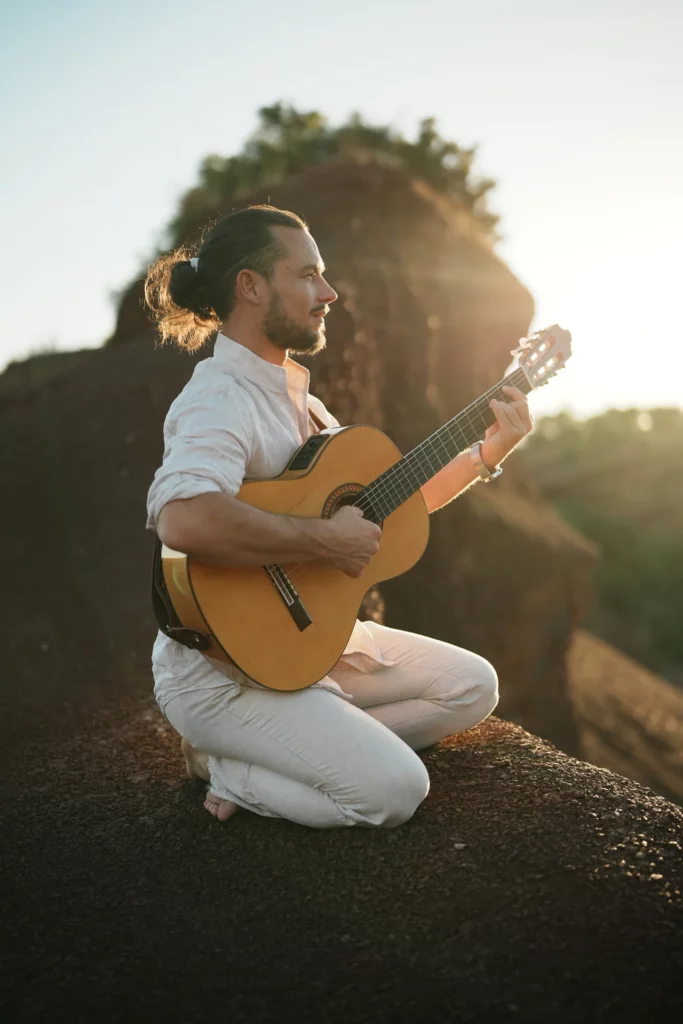 Guitarrista sentado sobre la roca roja, Astranova