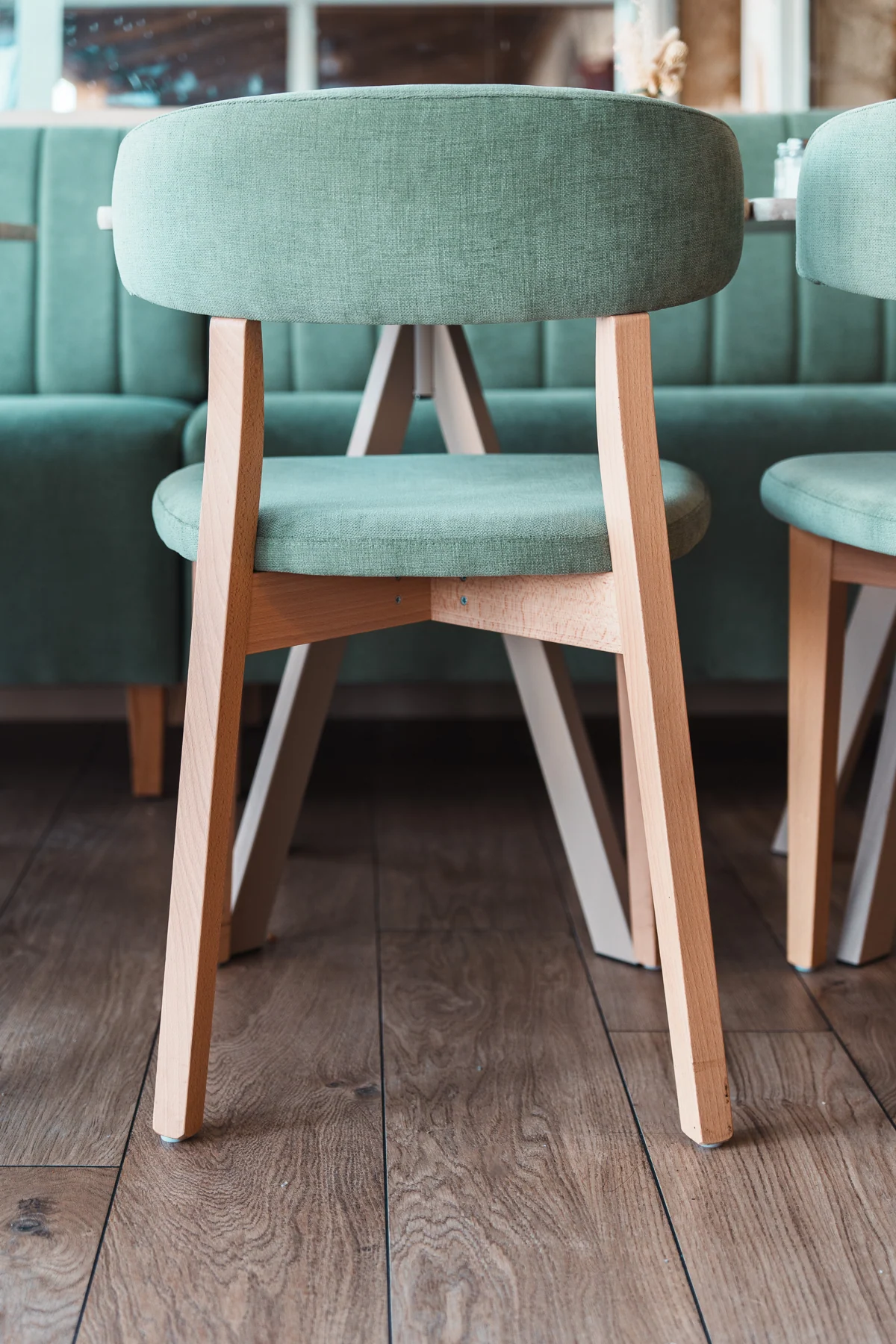 Detalle de una silla de madera tapizada en verde, CMobilier