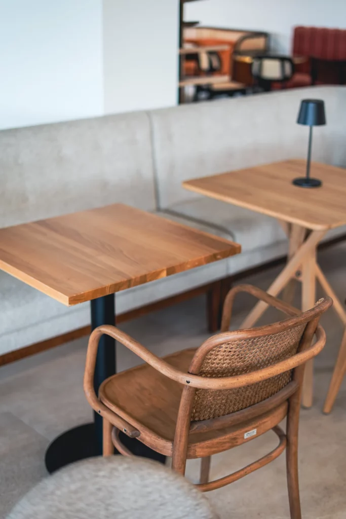 Tavoli e poltrona in legno nello showroom CMobilier di Frontignan
