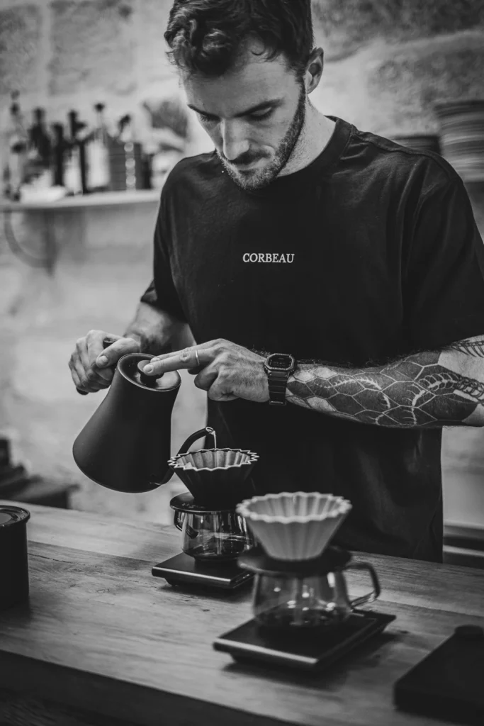 Le barista Corbeau prépare un café filtre, en noir et blanc