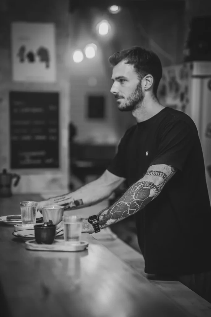 Le barista au comptoir de Corbeau, en noir et blanc