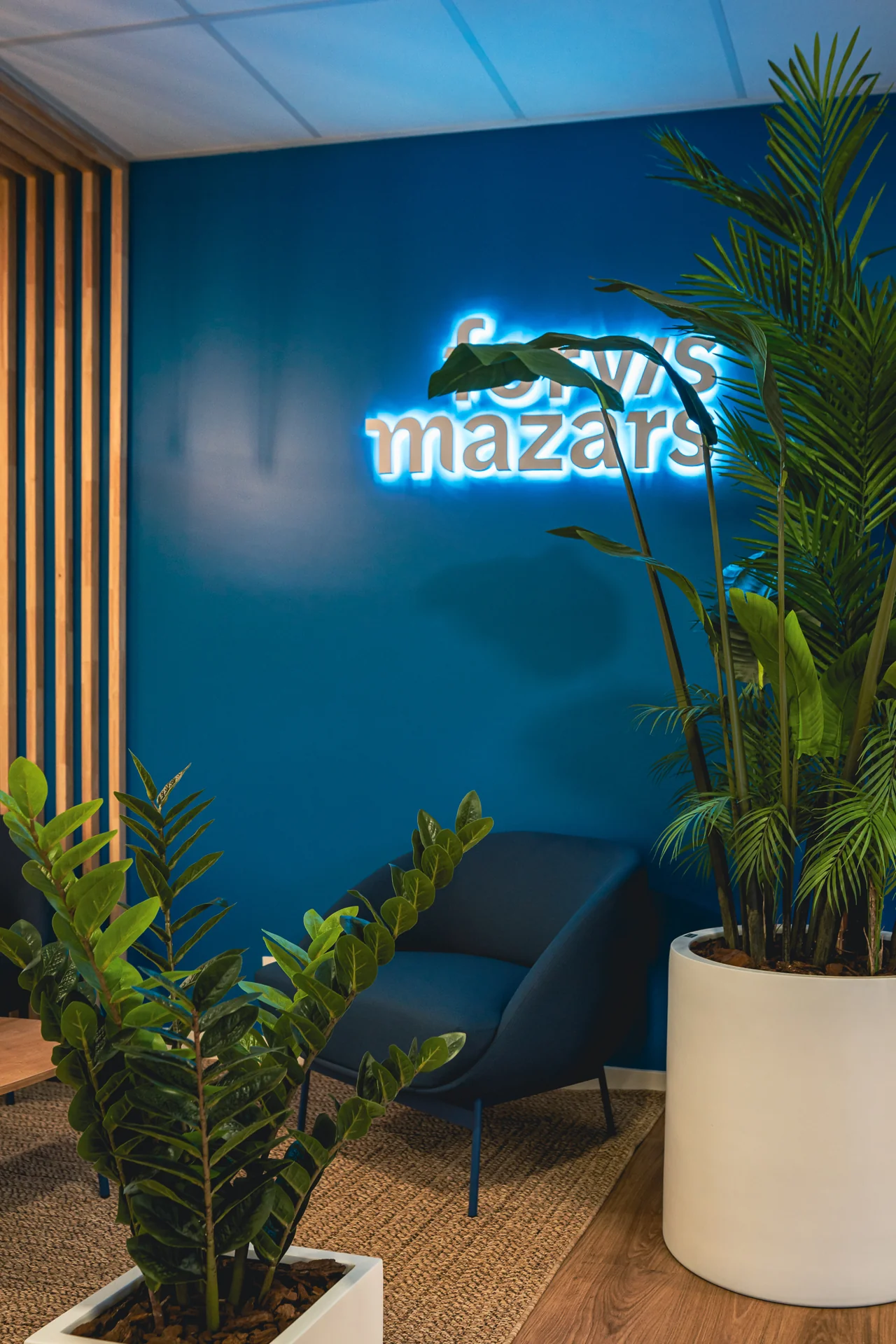 Sill&oacute;n, plantas y r&oacute;tulo luminoso de Forvis Mazars