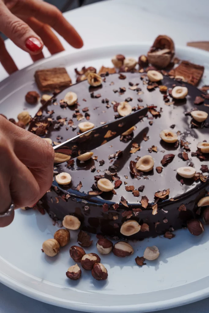 Corte de un pastel de chocolate y avellanas Graine de Vanille