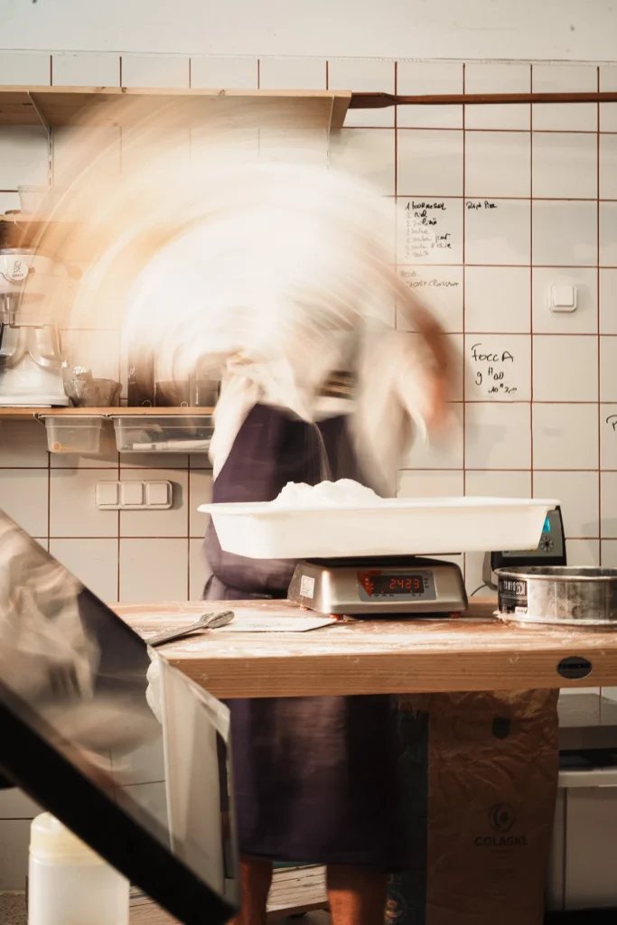Un boulanger en mouvement dans un nuage de farine chez Mamie