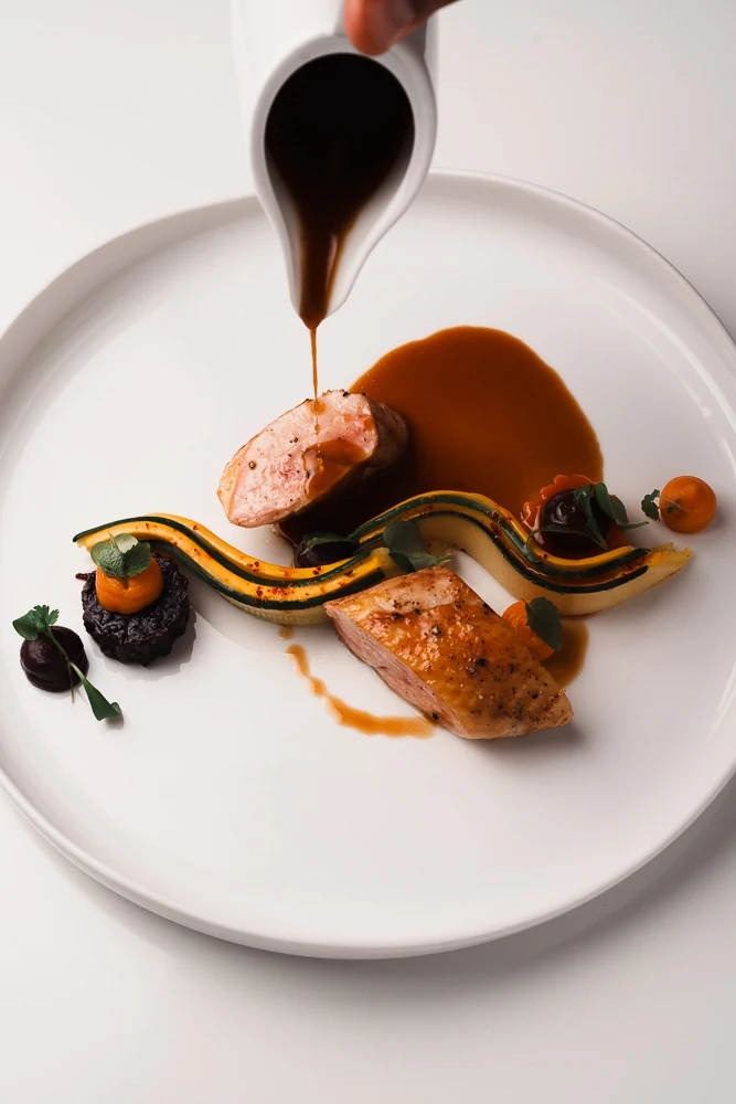 Le jus versé sur une assiette dressée à L’Essentiel