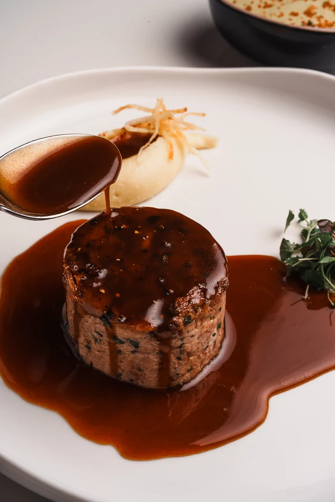 Salsa vertida sobre un plato en L&rsquo;Essentiel